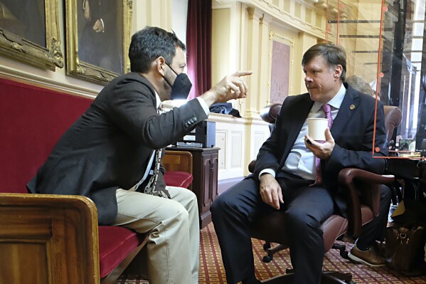 FILE -State Sen. Scott Surovell, D-Fairfax, left, and Sen. Ryan McDougle, R-Hanover, right, confer before the start of the floor session in the Virginia Senate in Richmond, Va., Friday, Jan. 28, 2022. Both Democrats and Republicans in the Virginia Senate have picked veteran legislators to lead their respective caucuses beginning in next year’s legislative session. Senate Democrats selected Scott Surovell on Wednesday to serve as majority leader. (Bob Brown/Richmond Times-Dispatch via AP)