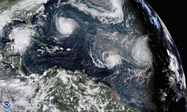 FILE - This enhanced satellite image made available by NOAA shows Tropical Storm Florence, upper left, in the Atlantic Ocean on Tuesday, Sept. 11, 2018 at 3:30 p.m. EDT. At center is Tropical Storm Isaac and at right is Hurricane Helene. According to a study released on Wednesday, Nov. 11, 2020, hurricanes are keeping their staying power longer once they make landfall, spreading more inland destruction. (NOAA via AP)