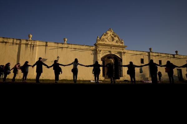 Women protest holding hands as they surround the San Bernardo Convent in Salta, Argentina, Tuesday, May 3, 2022. They women gathered in support of the convent's cloistered nuns who have accused the Archbishop of Salta province Mario Antonio Cargnello and other church officials of gender-based psychological and physical violence. (AP Photo/Natacha Pisarenko)