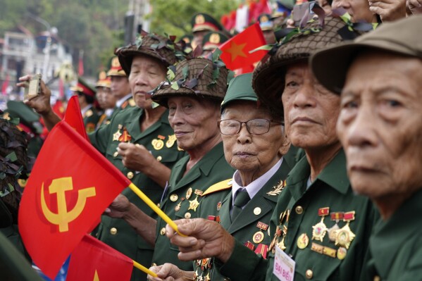 Veterans watch a parade commemorating the victory of Dien Bien Phu battle in Dien Bien Phu, Vietnam, Tuesday, May 7, 2024. Vietnam is celebrating the 70th anniversary of the battle of Dien Bien Phu, where the French army was defeated by Vietnamese troops, ending the French colonial rule in Vietnam. (AP Photo/Hau Dinh)
