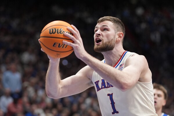Kansas center Hunter Dickinson shoots during the first half of an NCAA college basketball game against BYU Tuesday, Feb. 27, 2024, in Lawrence, Kan. (AP Photo/Charlie Riedel)