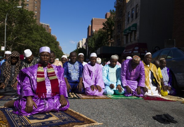 FILE - Imam Souleimane Konaté, left, leads worshippers in Eid al-Fitr prayer in New York on Sunday, June 25, 2017. (AP Photo/Michael Noble Jr., File)