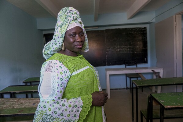 Maguette Diauf Fall, a teacher at Nouadhibou's Organization for the Support of Migrants and refugees, poses for a portrait in a classroom, Mauritania, Tuesday, Jan. 7, 2025. (AP Photo/Khaled Moulay)