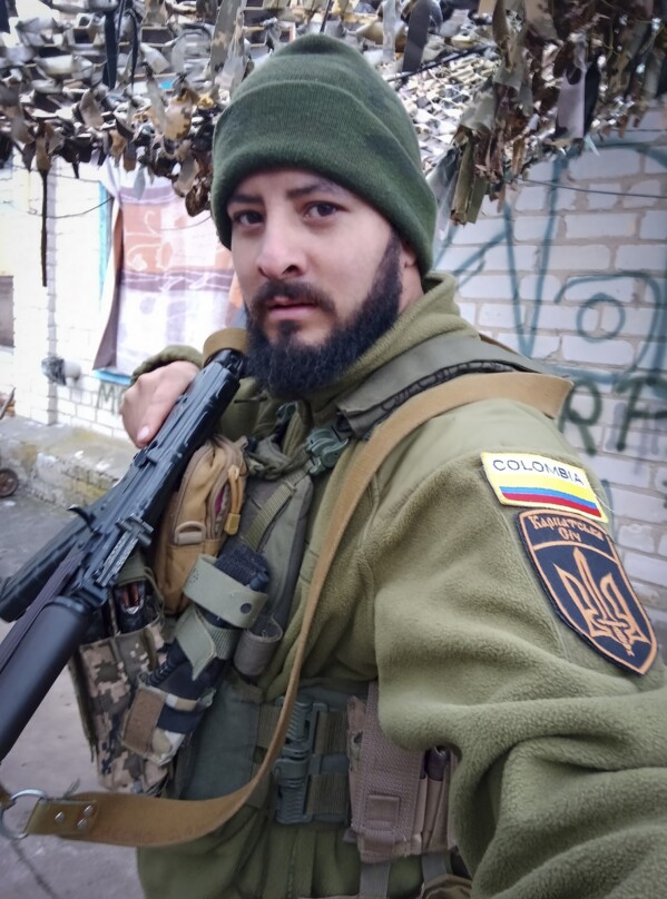 This 2023 photo provided by a 32-year-old professional soldier from Medellín, Colombia who goes by the call sign Checho shows him in his combat gear in Donbas, eastern Ukraine. Checho says he was struck by fire from a drone during a rescue operation to save a wounded colleague on the front line after three days of heavy fighting with Russian forces. At the hospital in the Kyiv region, Checho found himself with more than fifty other Colombians, most with light injuries sustained while fighting Russian forces in eastern Ukraine’s Donetsk region. They are among hundreds of Colombian veterans who have made the journey to Ukraine to help fight the Russians. (Courtesy of Checho via AP)