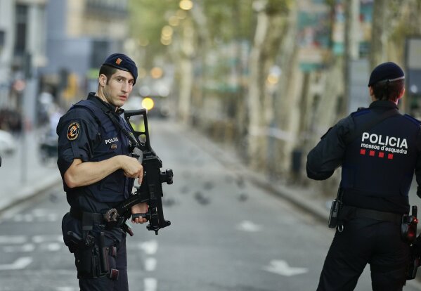 
              Armed police officers patrol a deserted street in Las Ramblas, in Barcelona, Spain, Friday, Aug. 18, 2017. A white van jumped up onto a sidewalk and sped down a pedestrian zone Thursday in Barcelona's historic Las Ramblas district, swerving from side to side as it plowed into tourists and residents. Police said 13 people were killed and more than 50 wounded in what they called a terror attack.(AP Photo/Manu Fernandez)
            