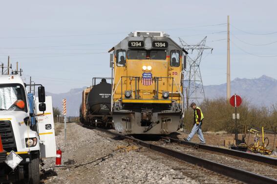 FILE - The crew on a Union Pacific freight train works at a siding, Friday, Jan. 24, 2020, south of Tucson, Ariz.  Union Pacific railroad plans to expand its use of renewable fuels and explore using battery-powered locomotives in the coming years to cut its emissions of greenhouse gases 26% by 2030. (AP Photo/David Boe, File)