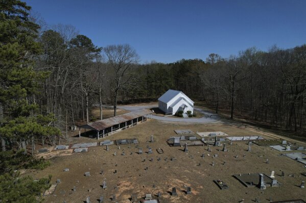 Trees encircle Holly Springs Primitive Baptist Church, which has been a historical meeting site for Sacred Harp singers for generations, in Bremen, Ga., on Sunday, March 23, 2025. (AP Photo/Jessie Wardarski)