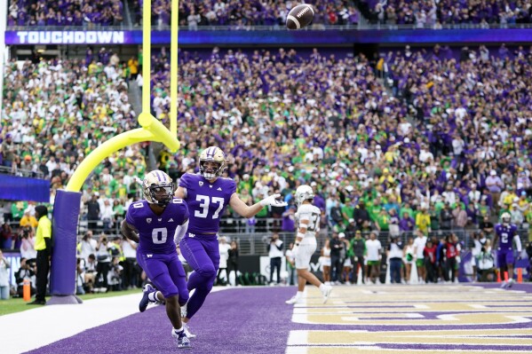 Washington wide receiver Giles Jackson (0) celebrates after scoring a touchdown with teammate Jack Westover (37) during the first half of an NCAA college football game against Oregon, Saturday, Oct. 14, 2023, in Seattle. (AP Photo/Lindsey Wasson)