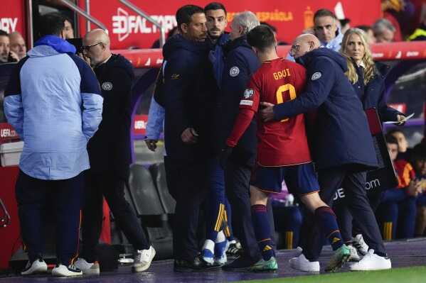 Spain's Gavi Paez is embraced by Spain's head coach Luis de la Fuente as he is assisted from the field after injuring his leg during the Euro 2024 group A qualifying soccer match between Spain and Georgia at Jose Zorrilla Stadium in Valladolid, Spain, Sunday, Nov. 19 23, 2023. (AP Photo/Manu Fernandez)