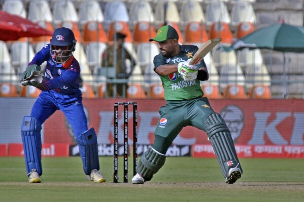 Pakistan's Babar Azam, right, plays a shot as Nepal's Aasif Sheikh watches during the one-day international cricket match of Asia Cup between Pakistan and Nepal, in Multan, Pakistan, Wednesday, Aug. 30, 2023. (AP Photo/Asim Tanveer)