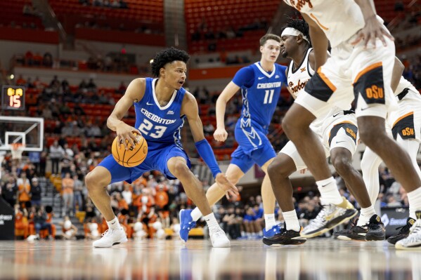 Creighton guard Trey Alexander (23) dribbles the ball in front of Oklahoma State guard John-Michael Wright in the first half of an NCAA college basketball game, Thursday, Nov. 30, 2023, in Stillwater, Okla. (AP Photo/Mitch Alcala)