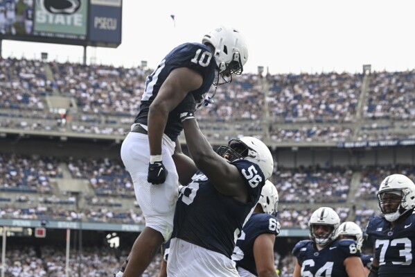 Penn State running back Nicholas Singleton (10) celebrates a touchdown with offensive lineman JB Nelson (56) during the first half of an NCAA college football game against Delaware, Saturday, Sept. 9, 2023, in State College, Pa. (AP Photo/Barry Reeger)