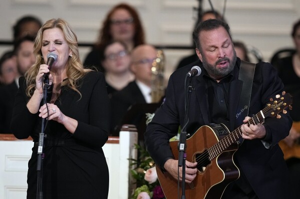 Garth Brooks and Trisha Yearwood perform "Imagine" at a tribute service for former first lady Rosalynn Carter at Glenn Memorial Church at Emory University on Tuesday, Nov. 28, 2023, in Atlanta. (AP Photo/Brynn Anderson, Pool)