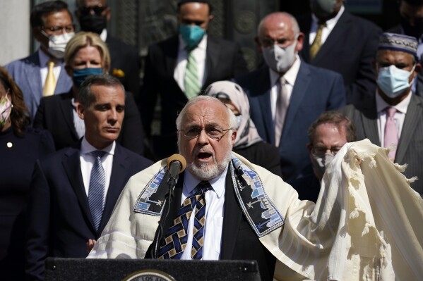 FILE- Rabbi Abraham Cooper, center, of the Simon Wiesenthal Center, speaks in front of civic and faith leaders outside City Hall, Thursday, May 20, 2021, in Los Angeles. A U.S. Congress-mandated group cut short a fact-finding mission to Saudi Arabia over officials in the kingdom ordering a Jewish rabbi to remove his kippah in public, highlighting the religious tensions still present in the wider Middle East. (AP Photo/Marcio Jose Sanchez, File)