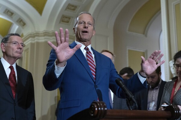 Senate Majority Leader John Thune, R-S.D., flanked by Sen. John Barrasso, R-Wyo., left, to reporters following weekly policy luncheons on Capitol Hill in Washington, Tuesday, May 13, 2025. (AP Photo/Jose Luis Magana)