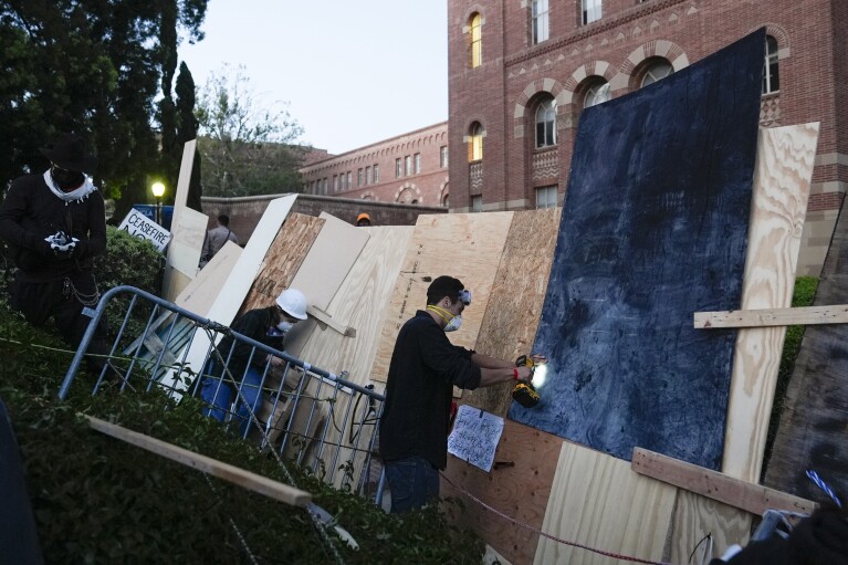 A person reinforces a barrier on the UCLA campus, after clashes between Pro-Israel and Pro-Palestinian groups the previous night, Wednesday, May 1, 2024, in Los Angeles. (AP Photo/Jae C. Hong)