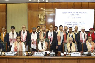 In this handout photograph released by the Press Information Bureau, Indian Home Minister, Amit Shah, center, poses for a photograph with the leaders of the United Liberation Front of Assam (ULFA) after signing a memorandum of settlement with them in New Delhi, India, Dec. 29, 2023. (Press Information Bureau via AP)