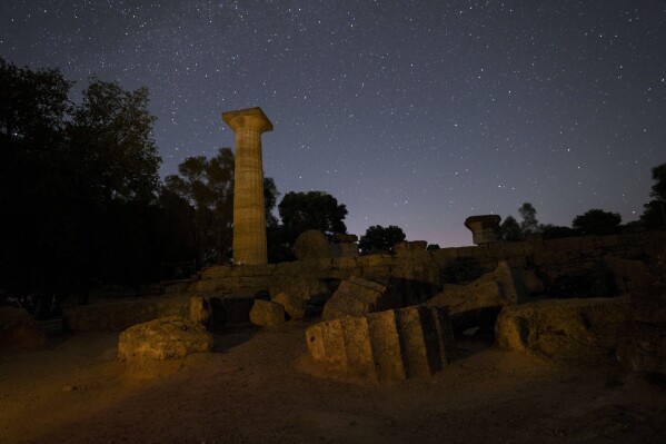 The 5th century B.C. temple of Zeus in ancient Olympia, birthplace of the Olympic Games, is seen under the stars, early Tuesday, April 9, 2024 in a night-time image made following special permission by the Culture Ministry. The ancient Olympic Games began in 776 BC. (AP Photo/Petros Giannakouris)