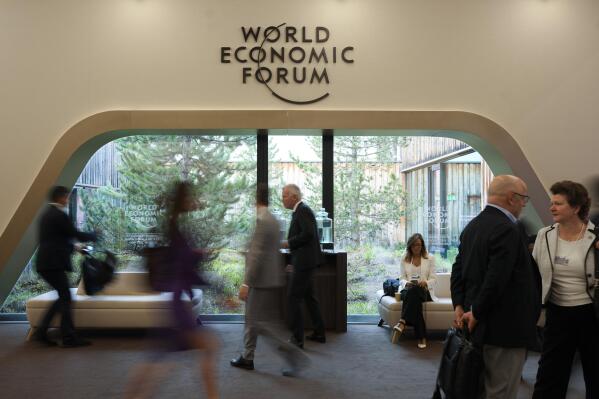 Participants walk through the Davos Congress Center, the venue of the annual meeting of the World Economic Forum in Davos, Switzerland, Monday, May. 23, 2022. The annual meeting of the World Economic Forum is taking place in Davos from May. 22 until May. 26, 2020. (AP Photo/Markus Schreiber)