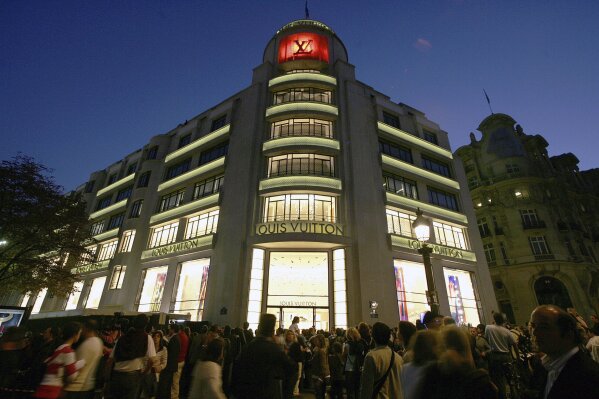 FILE - In this Oct. 9, 2005, file photo, a crowd gathers in front of French luxury goods maker Louis Vuitton's landmark store on the Champs Elysees in Paris, during its reopening ceremony after a 20-month redesign and enlargement project. In a statement on Tuesday, Dec. 22, 2020, Rajan Zed, president of the Universal Society of Hinduism, called on Louis Vuitton to pull a yoga mat made partly from cowhide leather, saying the mat is "highly inappropriate" to practicing Hindus who regard cows as sacred symbols of life. (AP Photo/Jacques Brinon, File)