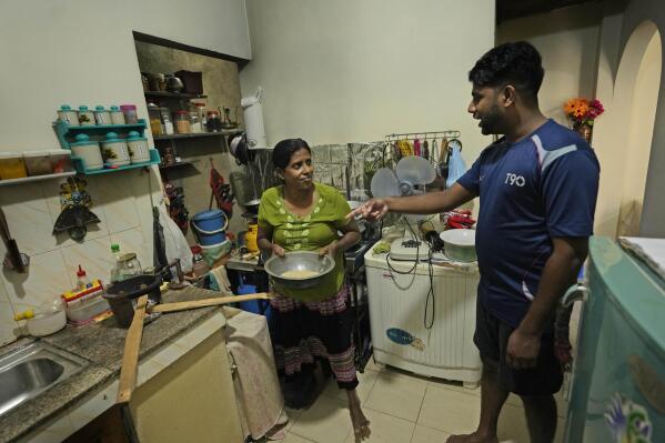 Miraj Madusanka, right, helps his mother Sriyani, to light a firewood hearth at their house in Colombo, Sri Lanka, Friday, June 10, 2022. Sri Lanka's economic crisis, the worst in its history, has completely recast the lives of the country's once galloping middle class. For many families that never had to think twice about fuel or food, the effects have been instant and painful, derailing years of progress toward lifestyles aspired to across South Asia. (AP Photo/Eranga Jayawardena)