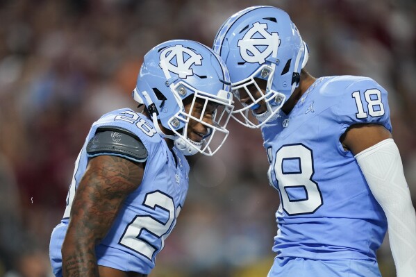North Carolina running back Omarion Hampton (28) celebrates after his touchdown with tight end Bryson Nesbit (18) during the first half of an NCAA college football game against South Carolina, Saturday, Sept. 2, 2023, in Charlotte, N.C. (AP Photo/Erik Verduzco)