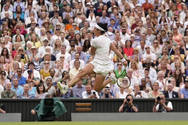 Tunisia's Ons Jabeur kicks the ball after failing to chase down a volley by Aryna Sabalenka of Belarus in their women's singles semifinal match on day eleven of the Wimbledon tennis championships in London, Thursday, July 13, 2023. (AP Photo/Alberto Pezzali)