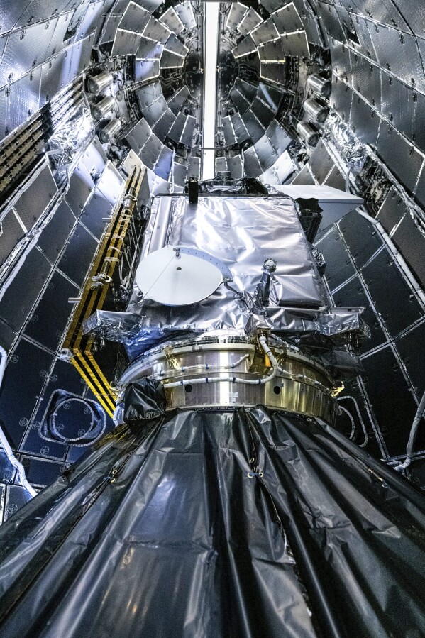 This image provided by NASA shows NASA and SpaceX technicians encapsulating NASA's PACE (Plankton, Aerosol, Cloud, ocean Ecosystem) spacecraft in SpaceX's Falcon 9 payload fairings on Tuesday, Jan. 30, 2024, at the Astrotech Space Operations Facility near the agency's Kennedy Space Center in Florida. (NASA via AP)