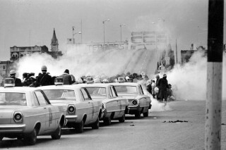FILE - Tear gas fills the air as state troopers, ordered by Alabama Gov. George Wallace, break up a march at the Edmund Pettus Bridge in Selma, Ala., March 7, 1965, on what became known as Bloody Sunday. (AP Photo, File)