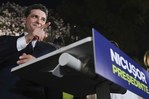 Presidential candidate Nicusor Dan gestures as he addresses supporters after polls closed for the first round of the country's presidential election redo in Bucharest, Romania, Sunday, May 4, 2025. (AP Photo/Eduard Vinatoru)