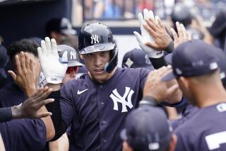 New York Yankees' Aaron Judge is congratulated after hitting a solo home run during the first inning of a spring training baseball game against the Atlanta Braves, Saturday, April 2, 2022, in Tampa, Fla. (AP Photo/Lynne Sladky)
