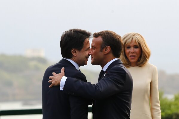 French President Emmanuel Macron and his wife Brigitte welcome Italian Premier Giuseppe Conte, left, at the Biarritz lighthouse, southwestern France, ahead of a working dinner Saturday, Aug.24, 2019. Shadowed by the threat of global recession, a U.S. trade war with China and the possibility of one against Europe, the posturing by leaders of the G-7 rich democracies began well before they stood together for a summit photo. (AP Photo/Francois Mori, Pool)
