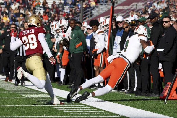 Miami wide receiver Colbie Young (4) stays in bounds on a pass reception during the first half of an NCAA college football game against Boston College, Friday, Nov. 24, 2023, in Boston. (AP Photo/Mark Stockwell)