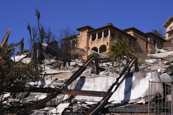 A home stands above debris from the Palisades Fire in Malibu, Calif., Sunday, Jan. 12, 2025. (AP Photo/Mark J. Terrill)