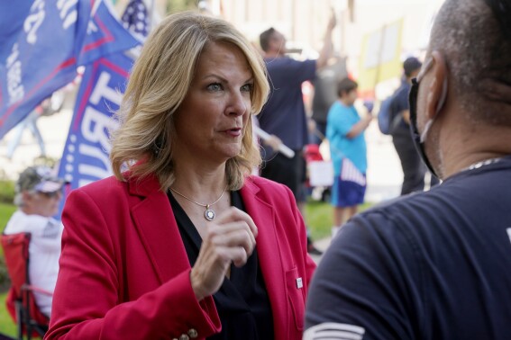 FILE - Dr. Kelli Ward, left, chair of the Arizona Republican Party, talks with a supporter of President Donald Trump as they join the crowd at a rally outside the Arizona Capitol, Nov. 7, 2020, in Phoenix. Ward is one of 11 Republicans in Arizona who submitted a document to Congress falsely declaring Donald Trump had beaten Joe Biden in the state during the 2020 presidential election were charged Wednesday, April 24, 2024 with conspiracy, fraud and forgery, marking the fourth state to bring charges against "fake electors." (AP Photo/Ross D. Franklin, File)