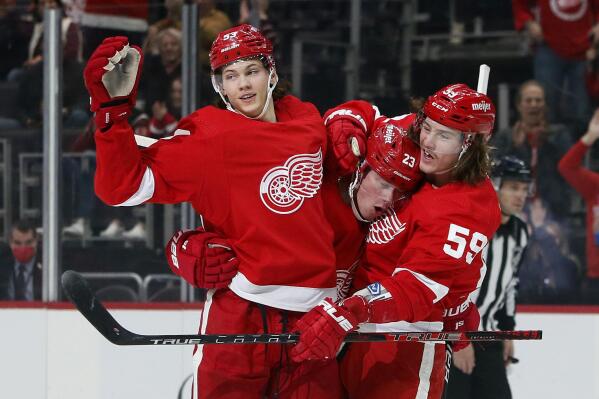 Detroit Red Wings left wing Lucas Raymond (23) celebrates with defenseman Moritz Seider (53) and left wing Tyler Bertuzzi (59) after scoring against the Vegas Golden Knights during the first period of an NHL hockey game, Nov. 7, 2021, in Detroit. The Red Wings have faded from relevance in the NHL due to a lack of elite talent. Help appears to be on the way. Reigning rookie of the year Moritz Seider, a savvy and skilled defenseman, and forward Lucas Raymond, coming off a 57-point debut season, provide the once-proud franchise with legitimate sources of optimism. (AP Photo/Duane Burleson)