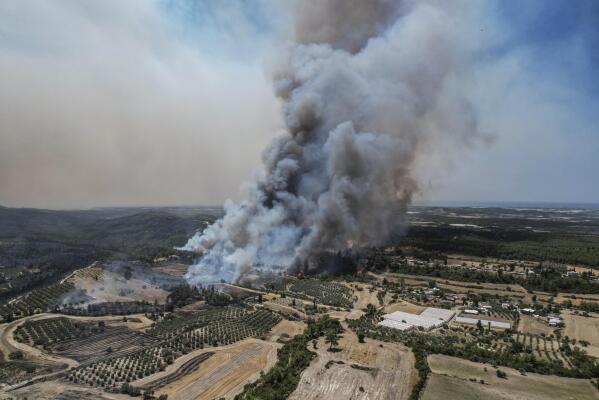 An aerial photo shows wildfires in Kacarlar village near the Mediterranean coastal town of Manavgat, Antalya, Turkey, Saturday, July 31, 2021. The death toll from wildfires raging in Turkey's Mediterranean towns rose to six Saturday after two forest workers were killed, the country's health minister said. Fires across Turkey since Wednesday burned down forests, encroaching on villages and tourist destinations and forcing people to evacuate. (AP Photo)