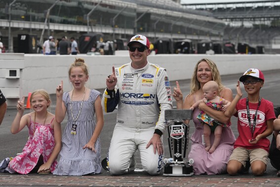 Michael McDowell celebrates with his family after winning the NASCAR Cup Series auto race at Indianapolis Motor Speedway, Sunday, Aug. 13, 2023, in Indianapolis. (AP Photo/Darron Cummings)