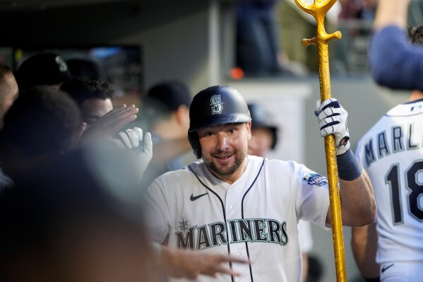 Seattle Mariners' Cal Raleigh holds a trident in the dugout after hitting a solo home run, his second of the the night, against the Boston Red Sox during the seventh inning of a baseball game, Monday, July 31, 2023, in Seattle. (AP Photo/Lindsey Wasson)