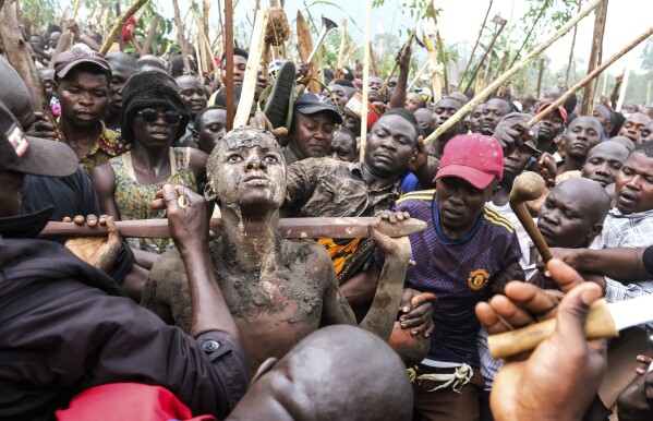 A mass circumcision is marketed to tourists in a remote area of Uganda.  Some are angrily objecting | AP News