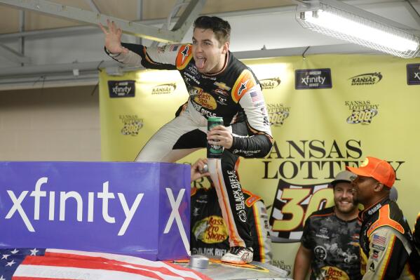 Noah Gragson celebrates his win in a garage area after a NASCAR Xfinity Series auto race at Kansas Speedway in Kansas City, Kan., Saturday, Sept. 10, 2022. The race was called after 93 laps due to rain. (AP Photo/Colin E. Braley)