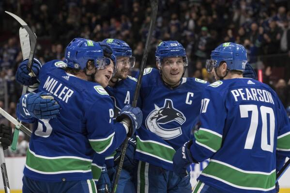 Vancouver Canucks' J.T. Miller, from left to right, Brock Boeser, Oliver Ekman-Larsson, of Sweden, Bo Horvat and Tanner Pearson celebrate Boeser's goal against the Los Angeles Kings during second period of an NHL hockey game in Vancouver, British Columbia, Monday, Dec. 6, 2021. (Darryl Dyck/The Canadian Press via AP)