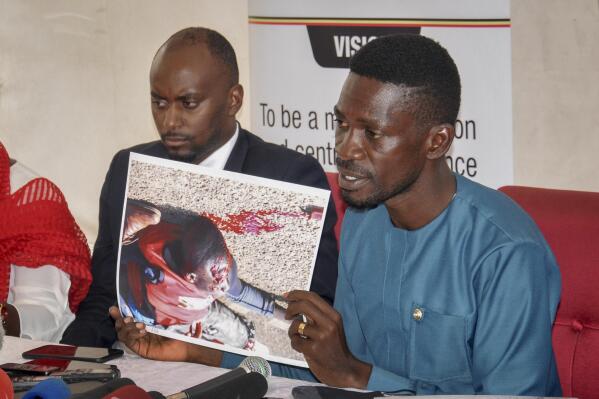 Ugandan opposition presidential candidate Bobi Wine shows a photograph depicting a victim of recent electoral-related violence in the country, at the Electoral Commission in Kampala, Uganda Wednesday, Dec. 2, 2020. Wine said Wednesday after meeting the head of the country's electoral body that he would resume his campaign after suspending it in protest over police brutality after police shot his car tires and fired rubber bullets that injured his bodyguards and supporters. (AP Photo/Ronald Kabuubi)
