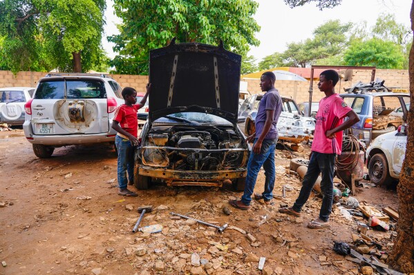 Mechanics work on a car in Niamey, Niger, Friday, Aug. 18, 2023. Niger, an impoverished country of some 25 million people, was seen as one of the last countries that Western nations could partner with in Africa's Sahel region to beat back a jihadi insurgency linked to al-Qaida and the Islamic State group. Before last month's coup, Europe and the United States had poured hundreds of millions of dollars into propping up its military. (AP Photo/Sam Mednick)