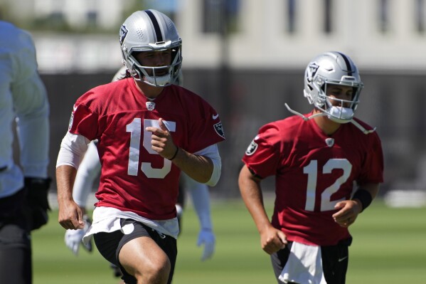 Las Vegas Raiders quarterback Gardner Minshew (15) and quarterback Aidan O'Connell (12) warm up during an NFL football practice Wednesday, June 12, 2024, in Henderson, Nev. (AP Photo/John Locher)