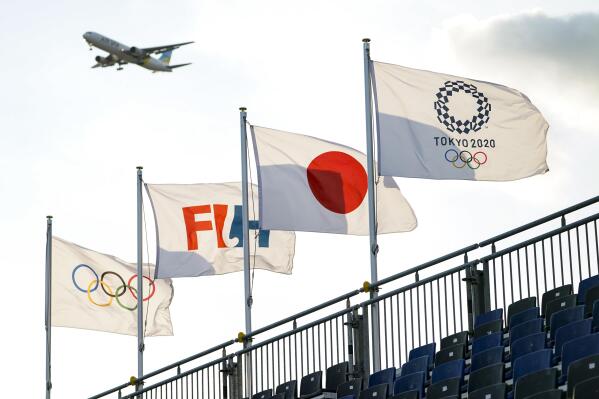 A commercial passenger jet approaches Haneda Airport above the field hockey complex at the 2020 Summer Olympics, Thursday, July 22, 2021, in Tokyo, Japan. (AP Photo/John Minchillo)