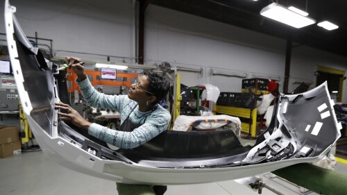 FILE- Mary Skinner inspects the rear end of a General Motors Chevrolet Cruze at Jamestown Industries in Youngstown, Ohio on Nov. 28, 2018. U.S. automakers and parts manufacturers have added nearly 90,000 jobs since January 2020 but it's hard to tease out just which economic gains can be credited to USMCA and which happened for a variety of unrelated reasons. (AP Photo/Tony Dejak, File)