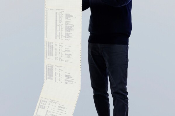 This 1975 photo provided by Gates Ventures shows Microsoft founder Bill Gates holding a printout of the computer coding that launched the software maker. (Ian Allen/Gates Ventures via AP)