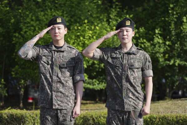 K-pop band BTS members Jimin, right, and Jung Kook salute after being discharged from a mandatory military service in Yeoncheon, South Korea, Wednesday, June 11, 2025. (AP Photo/Lee Jin-man)