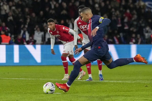 PSG's Kylian Mbappe scores his side's second goal from penalty spot during the French League One soccer match between Paris Saint-Germain and Monaco, at the Parc des Princes stadium in Paris, France, Friday, Nov. 24, 2023. (AP Photo/Michel Euler)